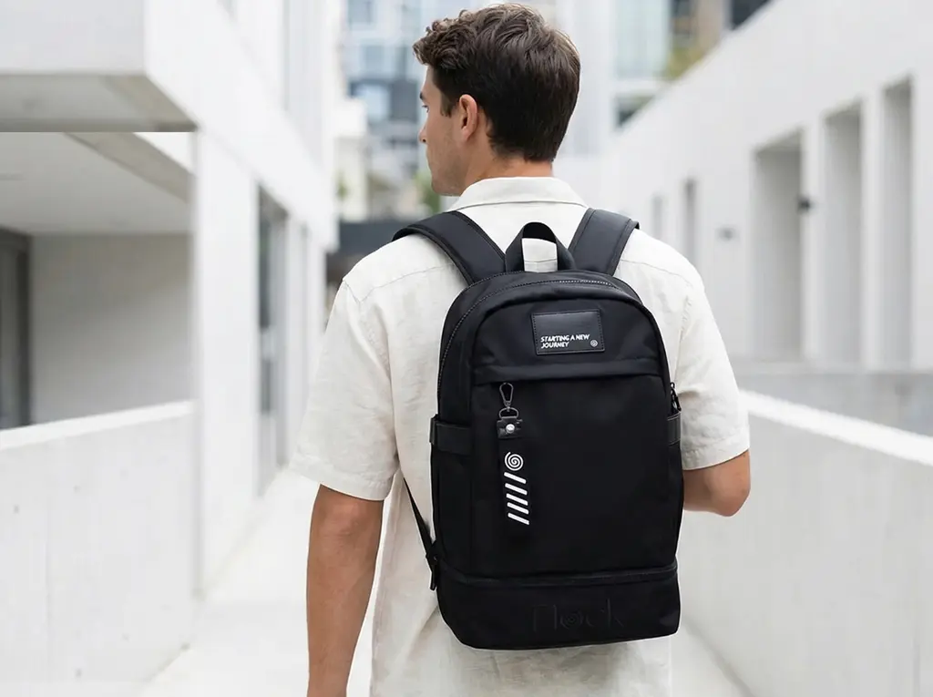 Persona cargando mochila negra en calle blanca urbana